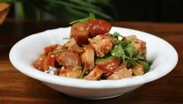 凉拌猪尾3,取一大碗,将过凉的猪皮放入碗中,加入盐,辣椒油,酱油,蒜末