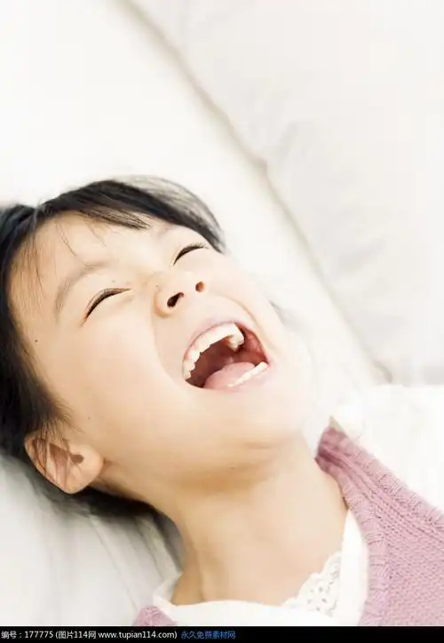 躺在床上张大嘴巴大笑的女孩