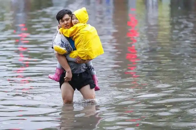 暴雨中为孩子挡雨 父爱深沉化作雨伞为孩子遮风挡雨暖哭网友