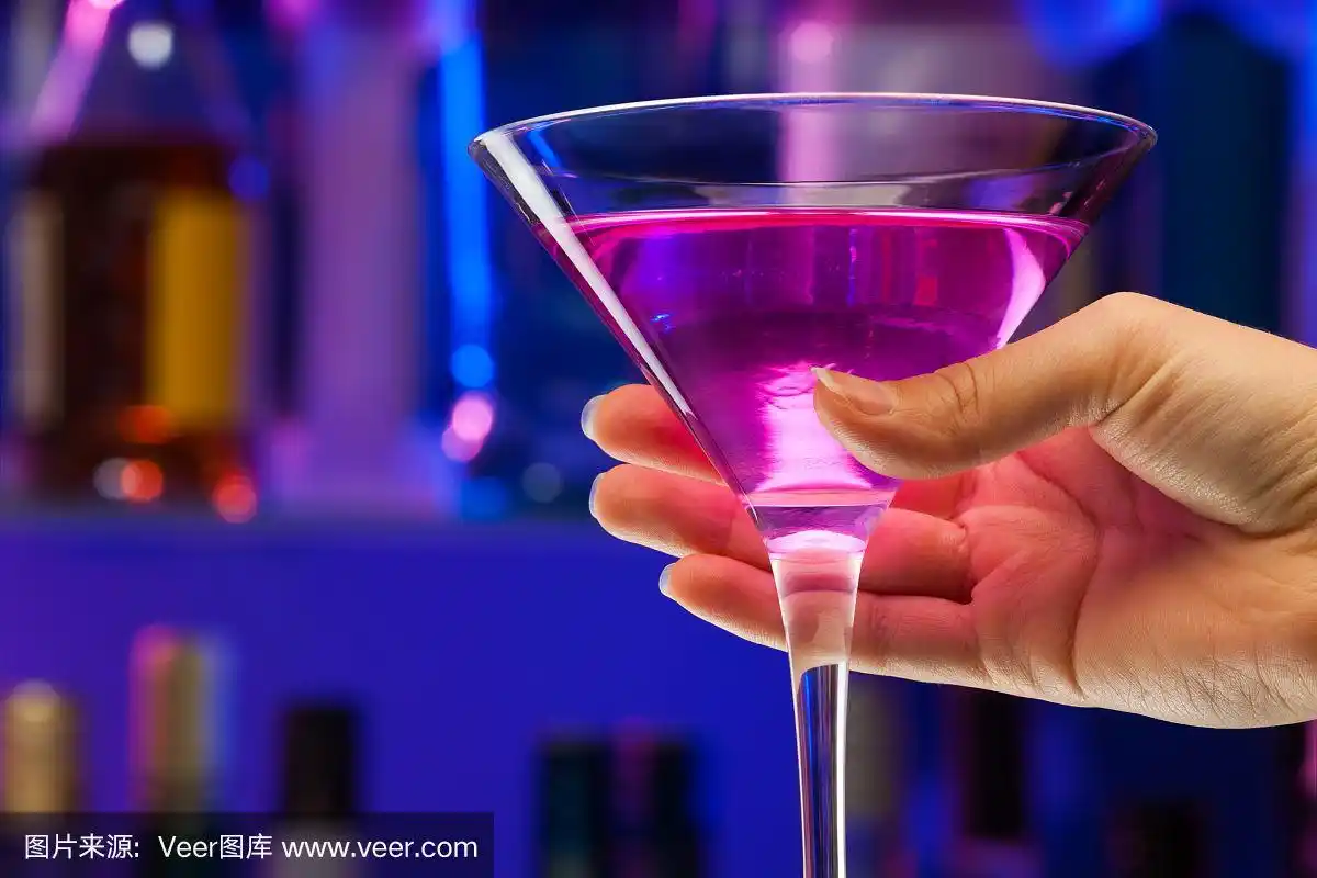 手握鸡尾酒杯在酒吧