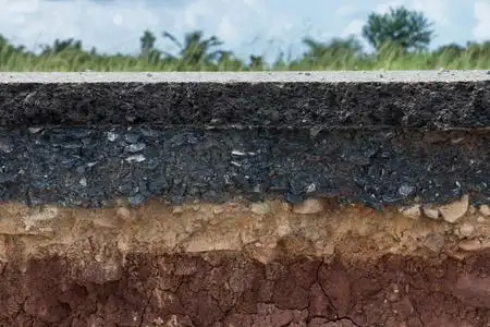 深色纹理黑色沥青路面与土壤和岩石的层土壤地质剖面图,煤层.